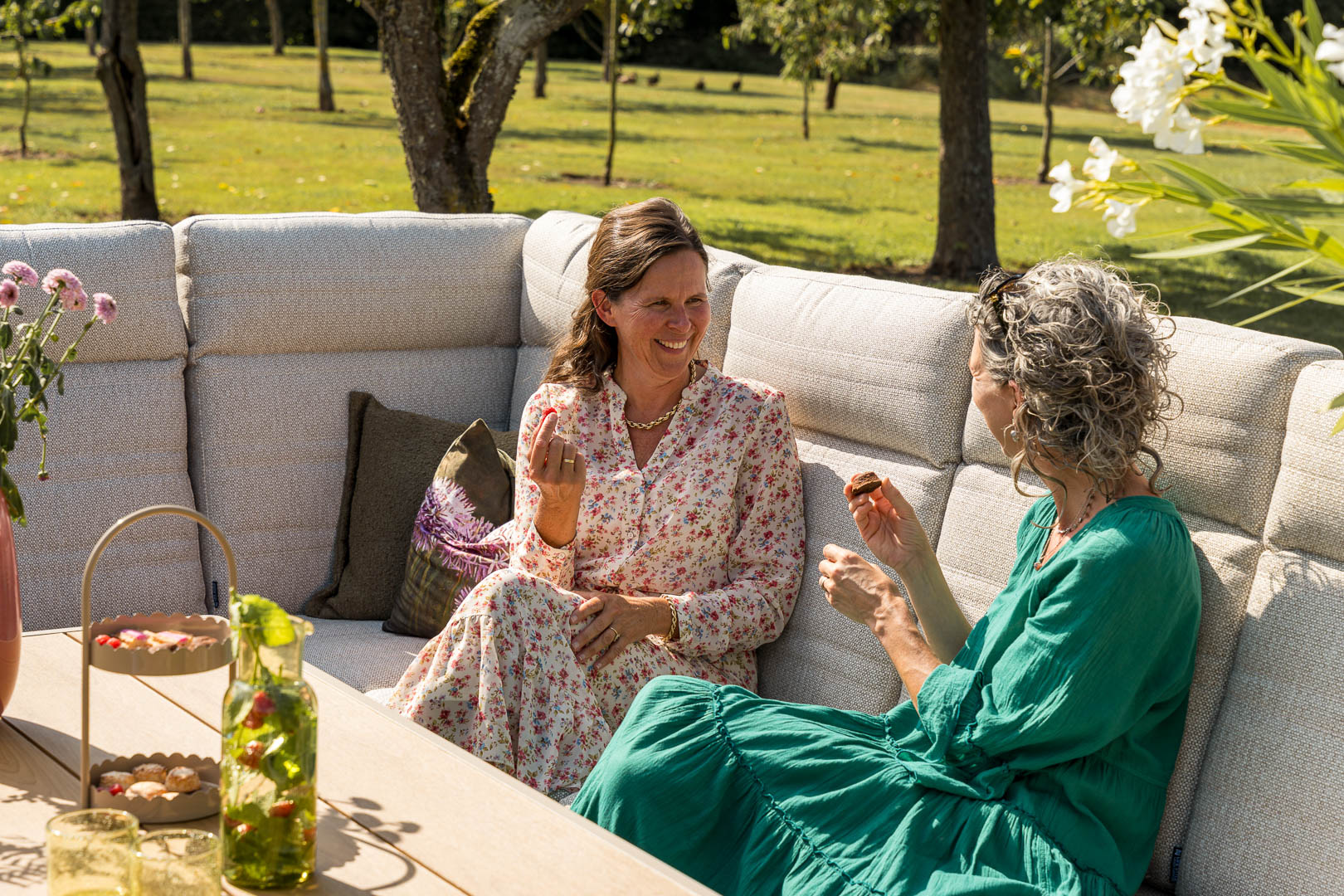 Mensen ontspannen in een landelijke tuin met loungeset